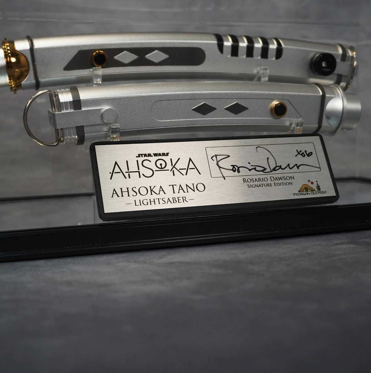 Rosario Dawson signature on the brushed metal Ahsoka Tano Signature Edition plaque, with both hilts behind