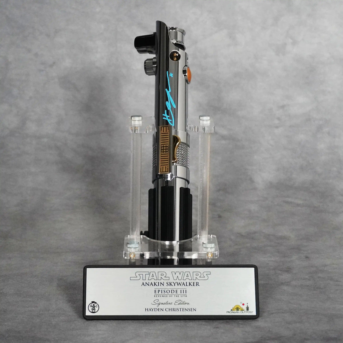 Signed Model Ani lightsaber upright on a clear display stand above the Signature Edition plaque