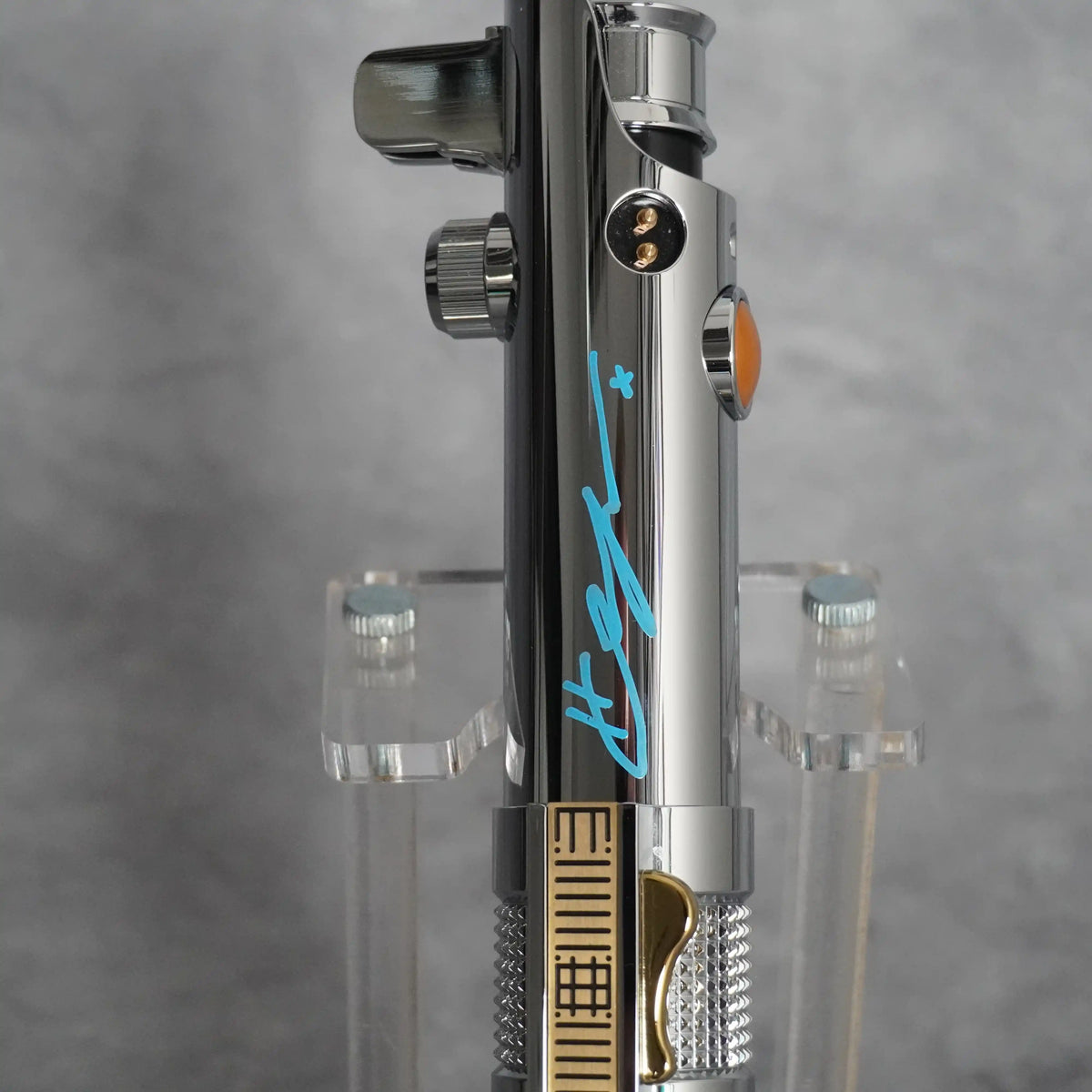 Close-up of Hayden Christensen's autograph on the polished chrome of the Anakin Episode III hilt