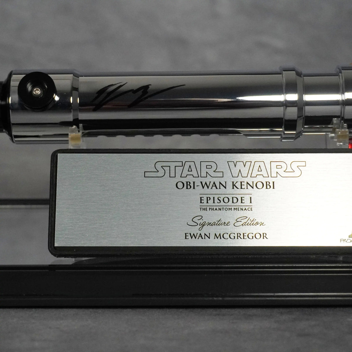 Ewan McGregor's black ink signature on the Obi-Wan Episode I hilt, above the brushed metal Signature Edition plaque