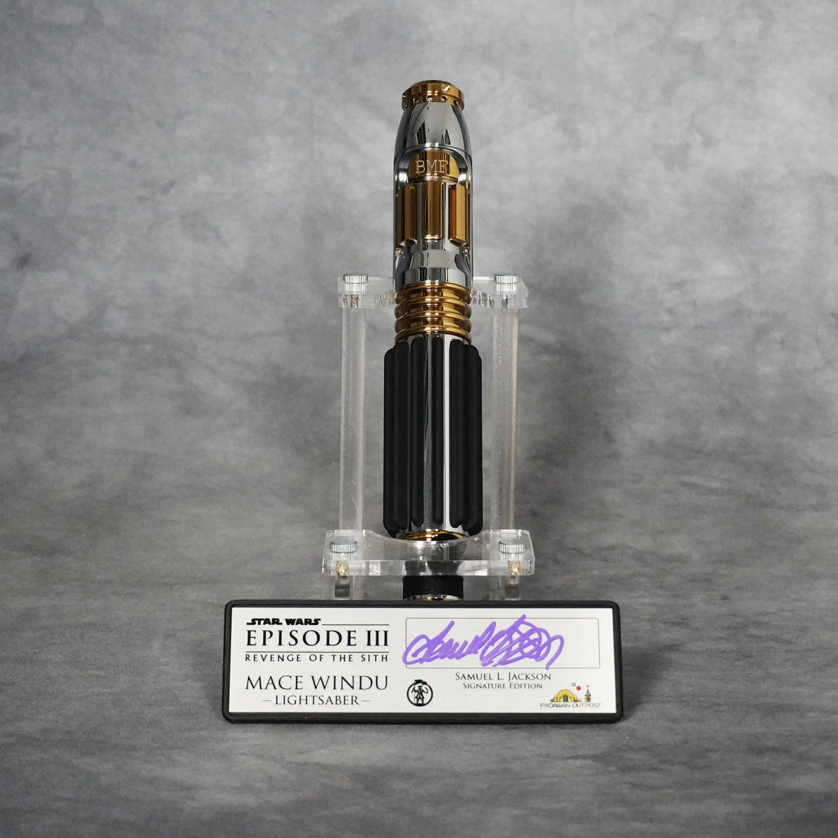 Signature Edition Mace Windu lightsaber upright on its stand with the BMF engraved emitter, above the brushed metal plaque signed by Samuel L. Jackson